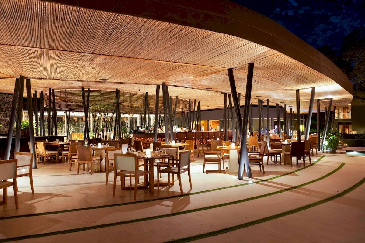 Innenansicht des Restaurants des El Mangroove, Autograph Collection mit runden Tischen und Stühlen unter einer runden Bambusdecke.