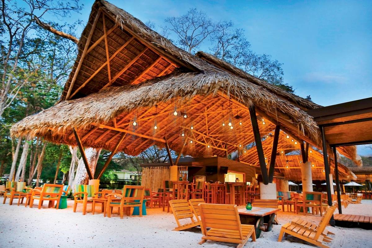 Terrasse des El Mangroove, Autograph Collection Hotels mit bunten Stühlen und Tischen.