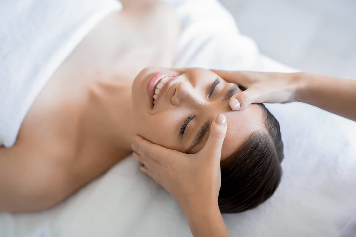 Frau im Hotel Spa wird eine Gesichtsmassage gemacht