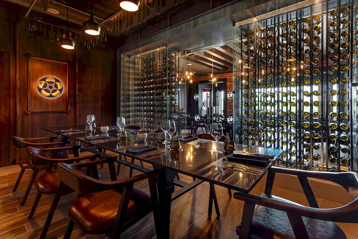 Innenansicht des Restaurants im Planet Hollywood Beach Resort mit Tisch und Weinkeller.