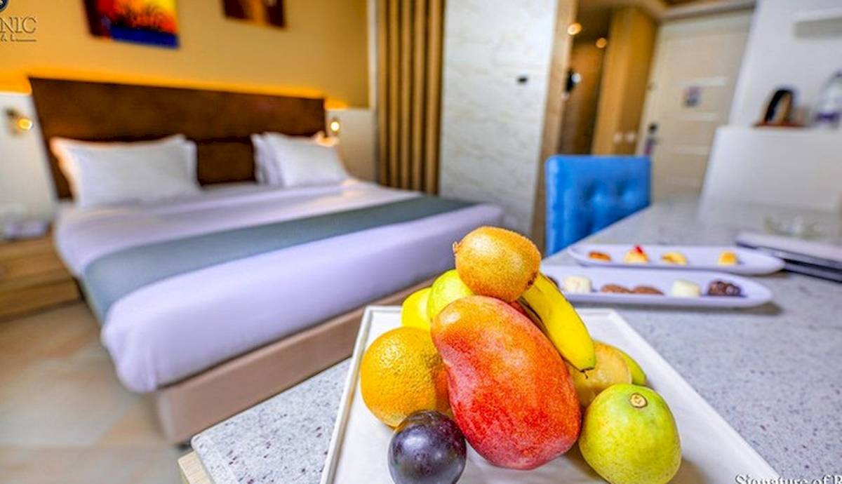 Hotelzimmer des Titanic Royal mit einem Bett und einer Obstplatte auf dem Tisch.