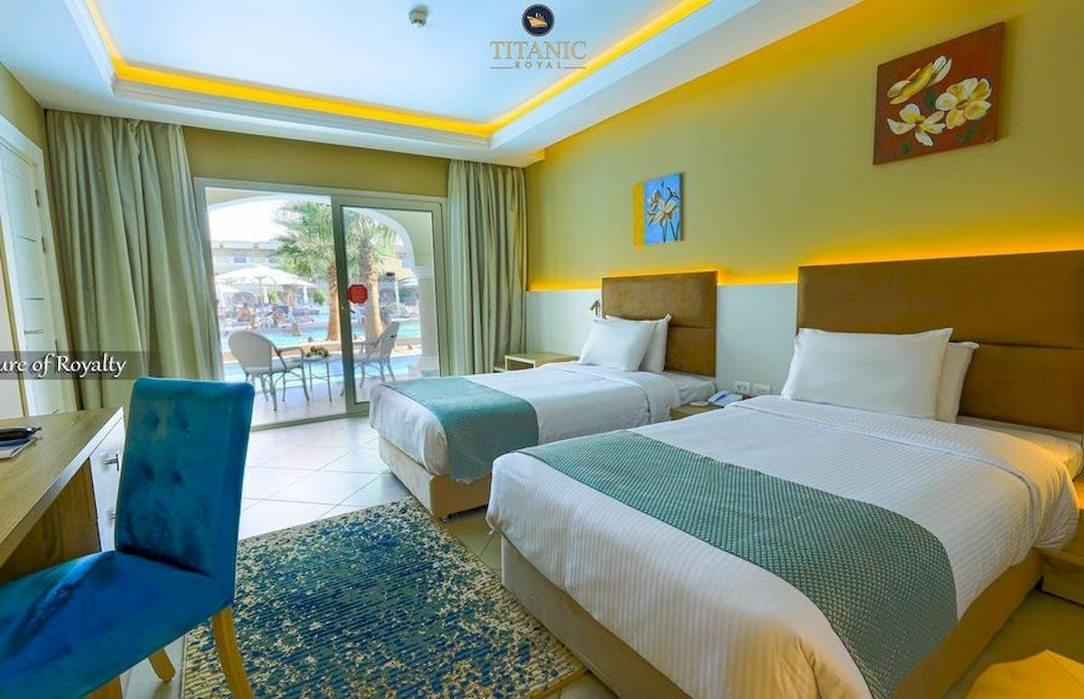 Doppelzimmer im Titanic Royal Hotel mit zwei Betten, Blick auf den Pool und Terrasse