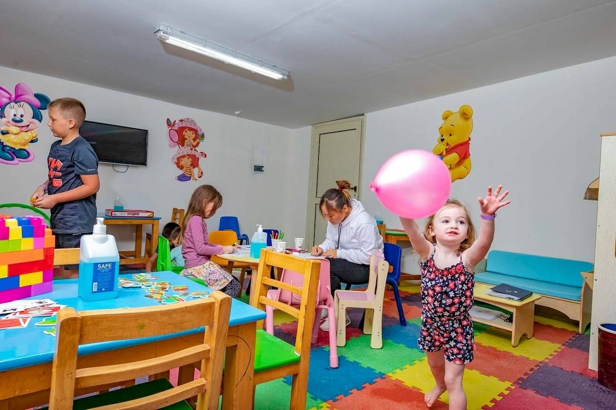 Ein Kinderzimmer im Titanic Resort & Aqua Park mit bunten Möbeln, Spielzeug und Kindern, die spielen.