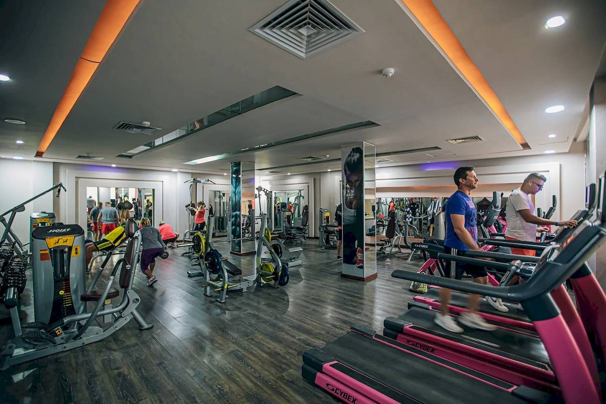 Fitnessstudio im Titanic Resort mit verschiedenen Geräten und Menschen, die trainieren