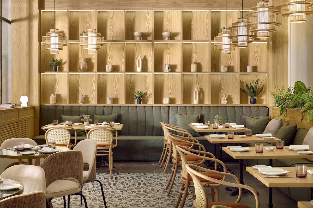 Inneneinrichtung des Melia Durres Albania Hotels mit Holzregalen, Sesseln und Tischen.