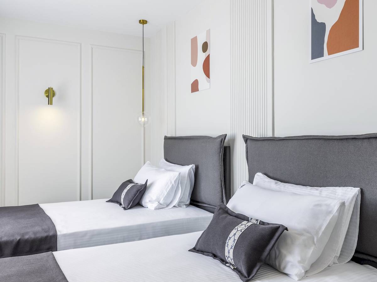 Doppelbett-Zimmer im Mövenpick Hotel Lalez Durres mit modernen Möbeln und weißen Wänden.