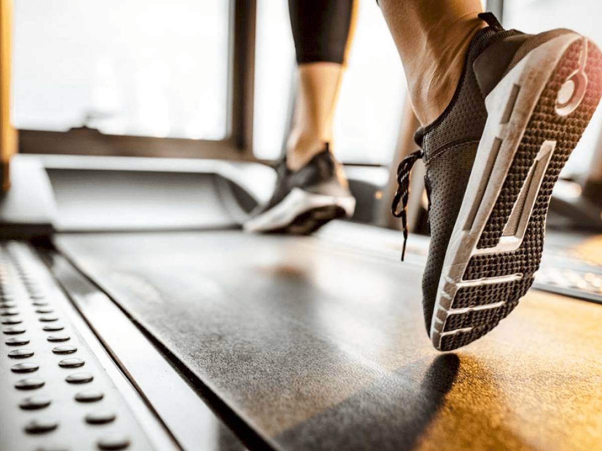 Person, die auf einem Laufband im Fitnessstudio läuft.