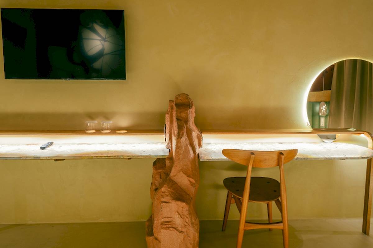 Arbeitsbereich im Zimmer des Epidamn White Sensation Hotels mit Schreibtisch, Stuhl, Fernseher und Fernbedienung.