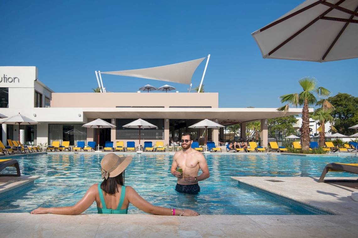 Mann und Frau neben dem Pool im Emotions By Hodelpa Hotel.