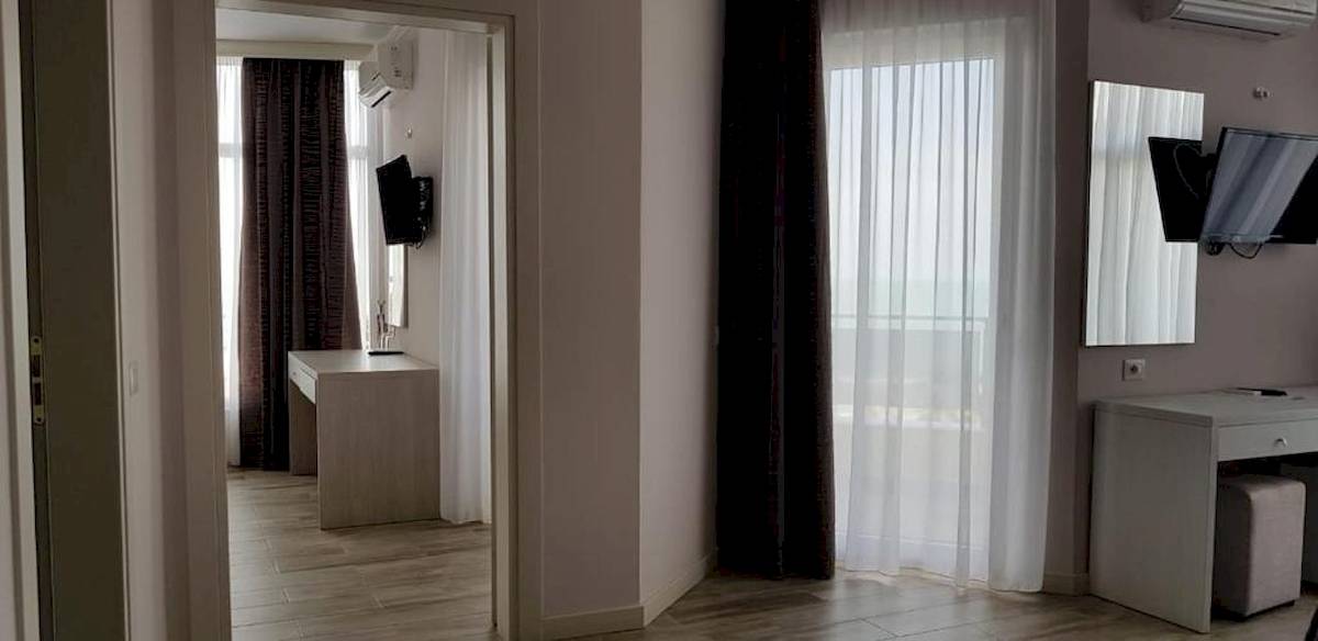Innenansicht eines Hotelzimmers im Klajdi Resort & SPA, mit Schreibtisch, Fernseher und Spiegel.