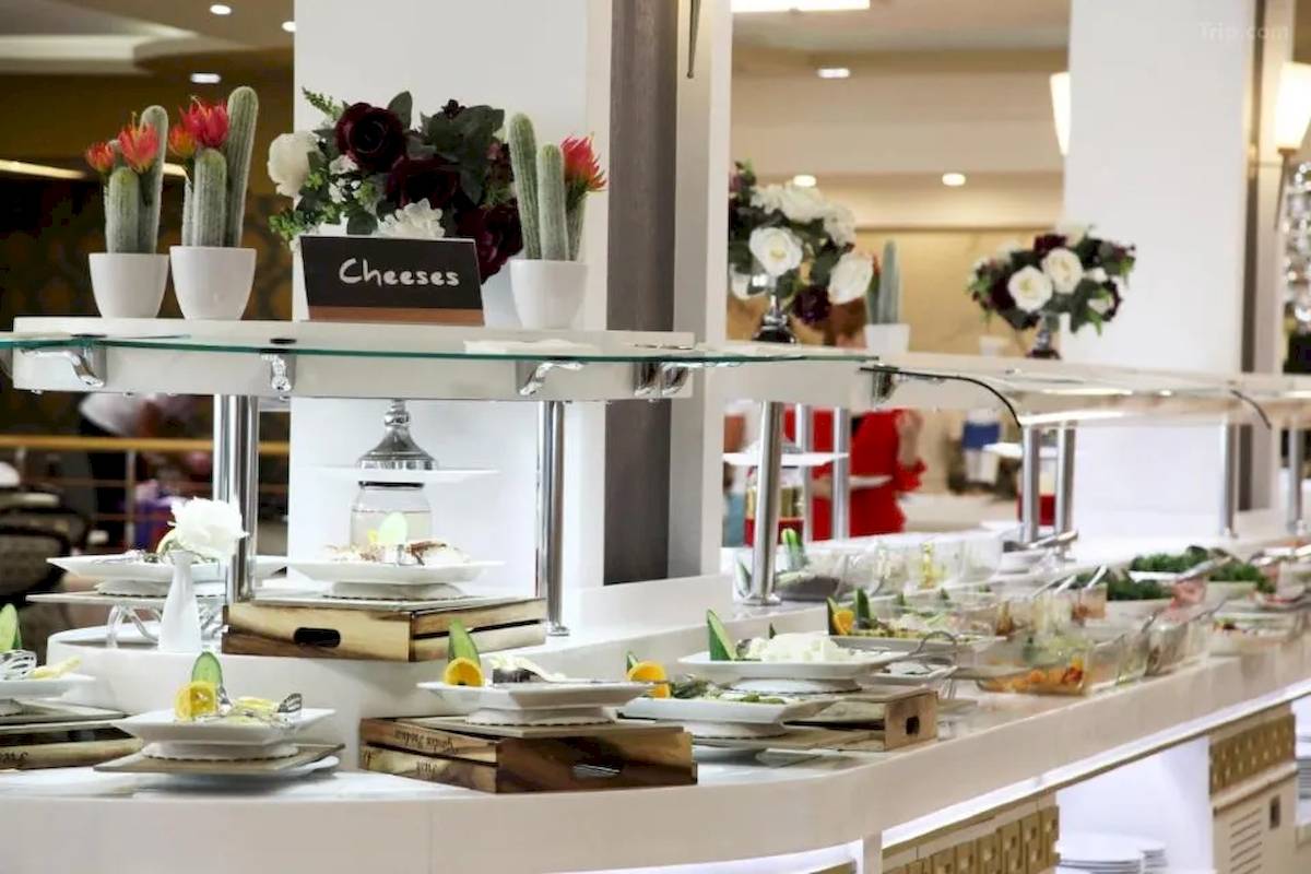 Buffet-Tisch im Fafa Beach Hotel mit Käse-Angebot und Blumen-Dekoration.