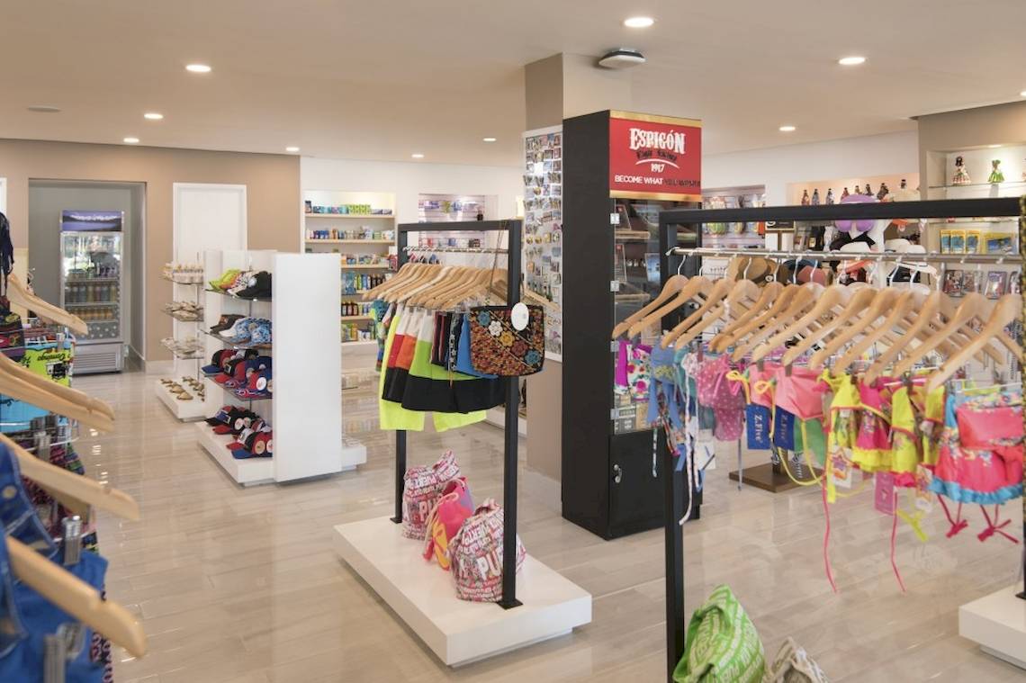 Innenansicht der Boutique im Emotions By Hodelpa Hotel in Puerto Plata mit verschiedenen Kleidungsstücken und Accessoires.