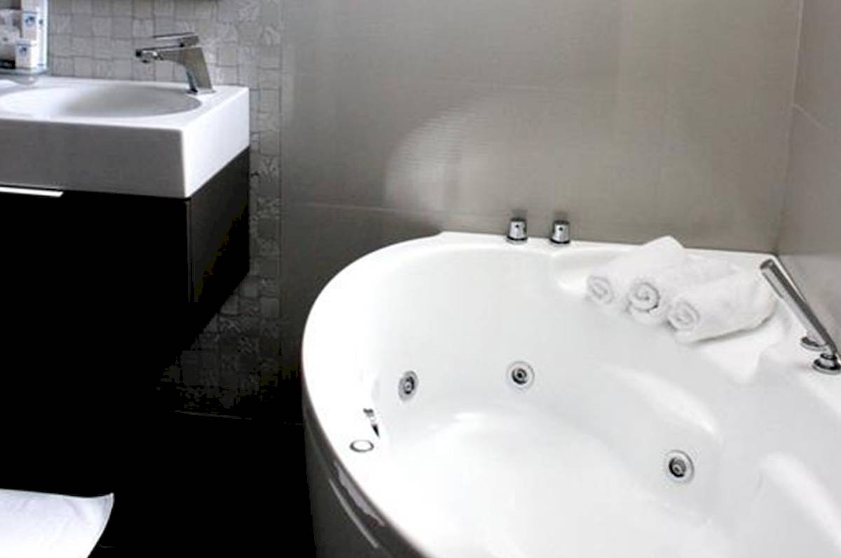 Badezimmer mit Badewanne im Demi Hotel