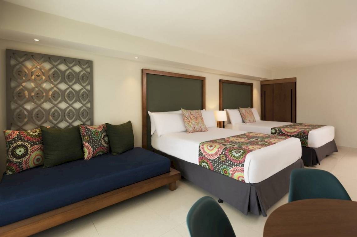 Schlafzimmer im Emotions By Hodelpa Hotel in Puerto Plata mit zwei Betten und einem Sofa.