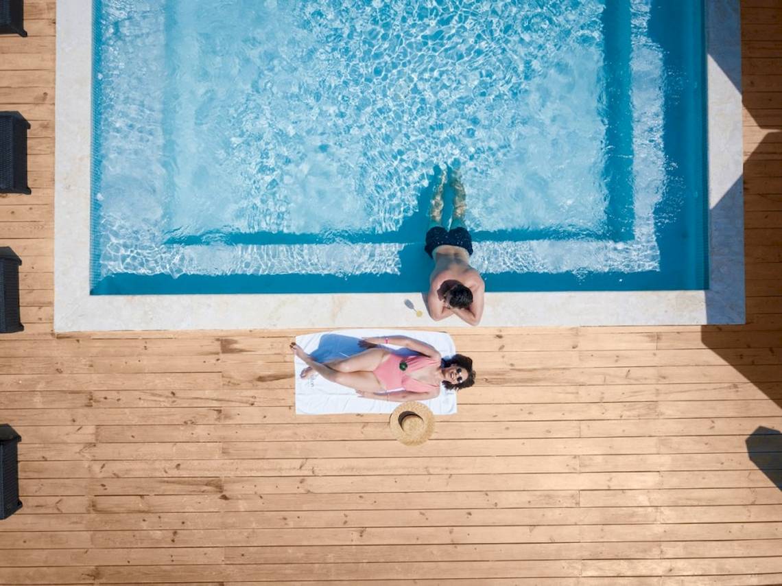 Ein Paar im Emotions By Hodelpa Hotel genießt das Schwimmbad auf der Terrasse.