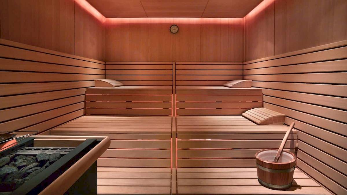 Innenansicht einer Sauna im Grand Hyatt Dubai mit Holzwänden, Liegen und einem Eimer.