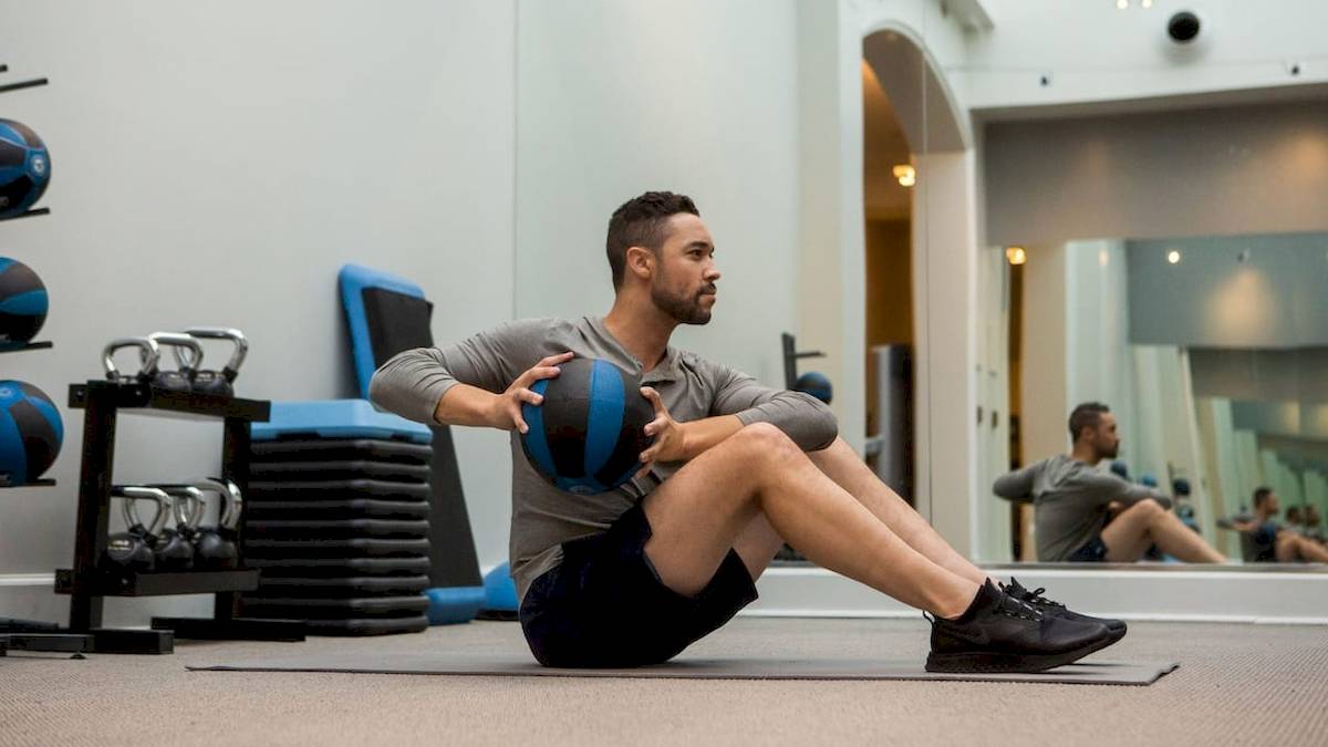 Ein Mann trainiert in einem Fitnessstudio mit einem Medizinball.