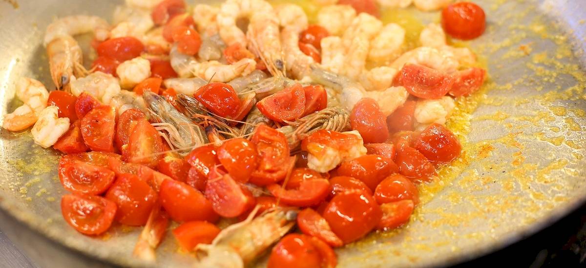 Garnelen und Tomaten in einer Pfanne gekocht mit etwas Öl