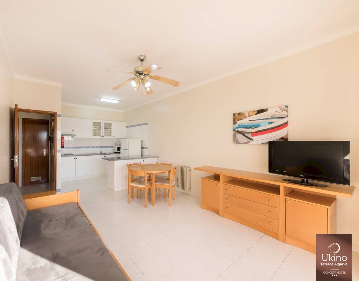 Inneneinrichtung des Ukino Terrace Algarve Hotels mit Wohnzimmer, Tisch, Fernseher und Küche