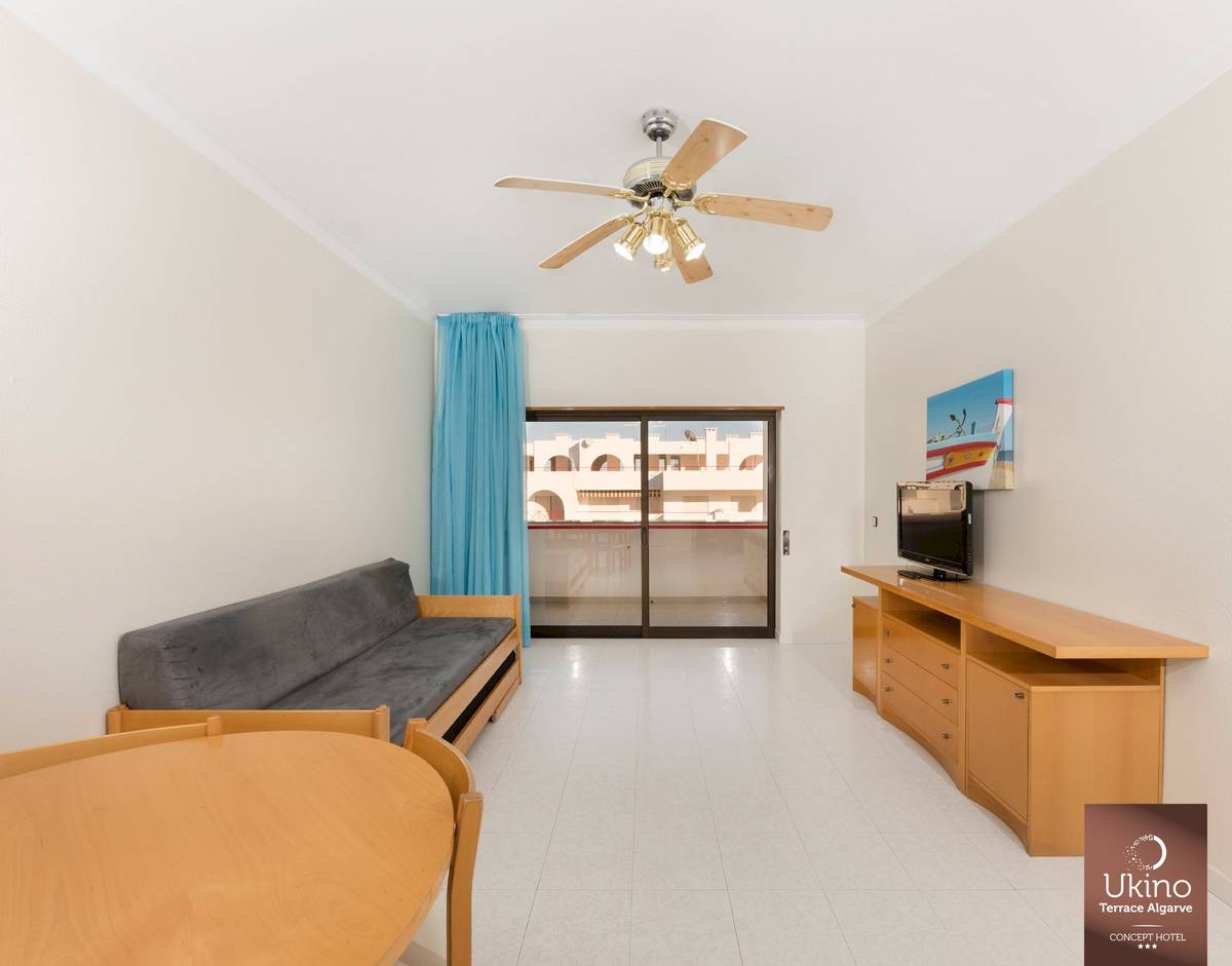Wohnzimmer mit Sofa, Tisch, Fernseher und Klimaanlage im Ukino Terrace Algarve.
