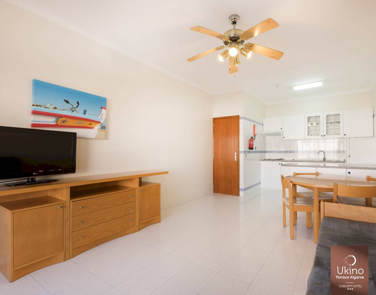 Inneneinrichtung des Ukino Terrace Algarve mit Wohnzimmer, Esstisch, Fernseher und Küche