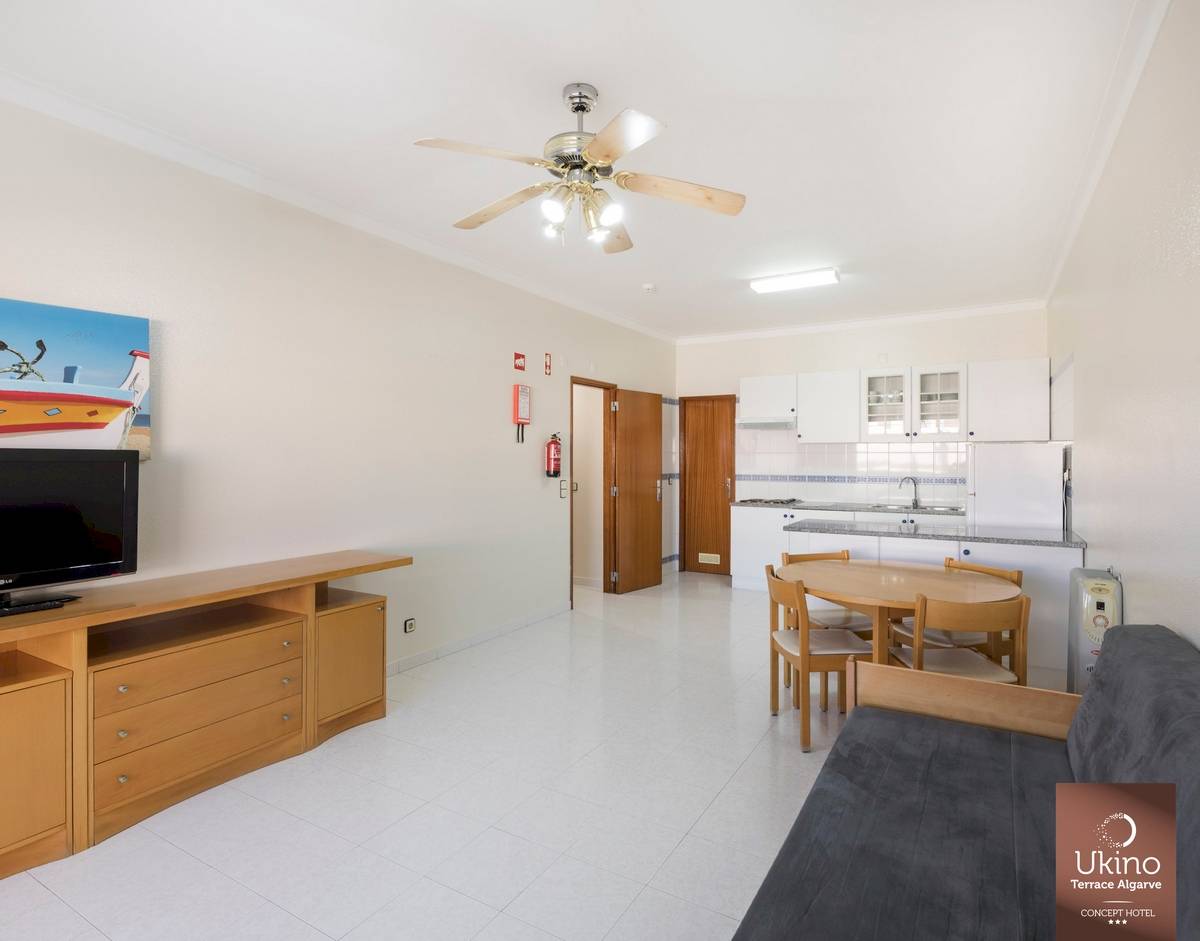 Innenbereich des Ukino Terrace Algarve Hotels mit Wohnzimmer, Küche und Esstisch.