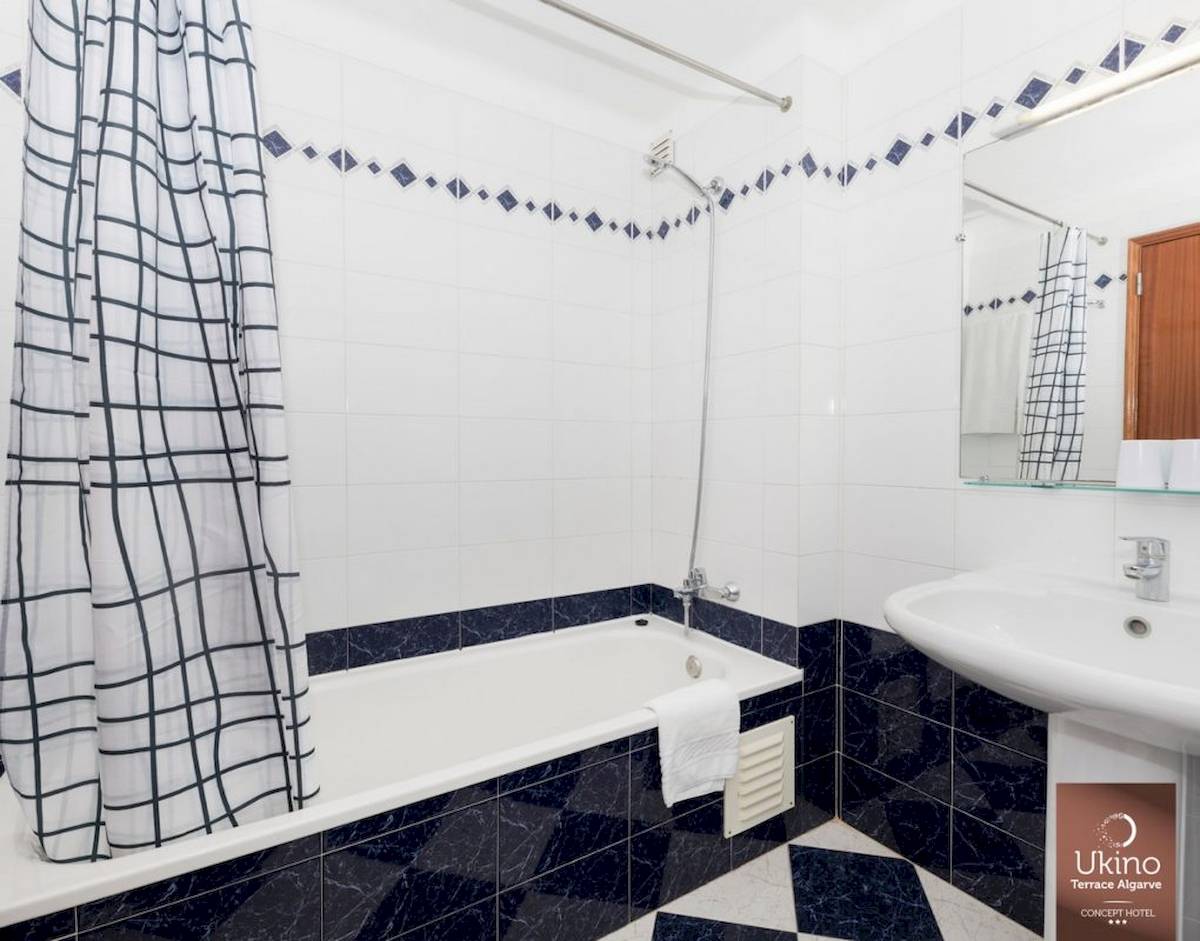 Badezimmer im Ukino Terrace Algarve Hotel mit Badewanne und Dusche