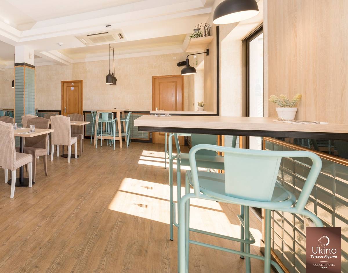Innenbereich des Restaurants im Ukino Terrace Algarve Hotel mit Holzboden und modernen Möbeln.