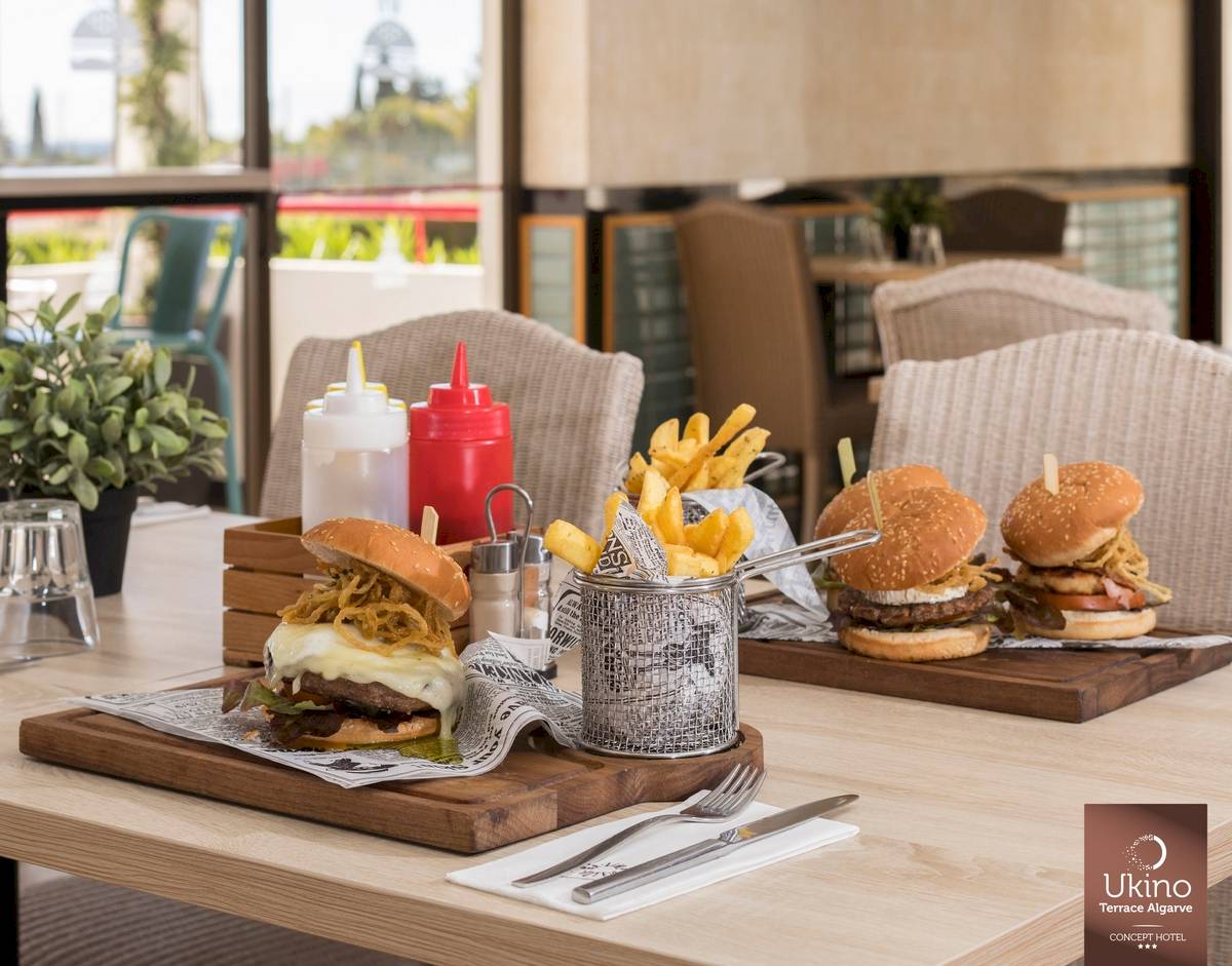 Restauranttisch im Ukino Terrace Algarve mit Burgern, Pommes und Beilagen