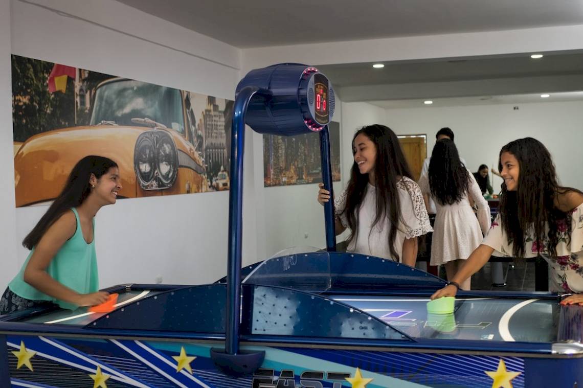 Jugendliche spielen Air Hockey im Emotions By Hodelpa Hotel in Puerto Plata.