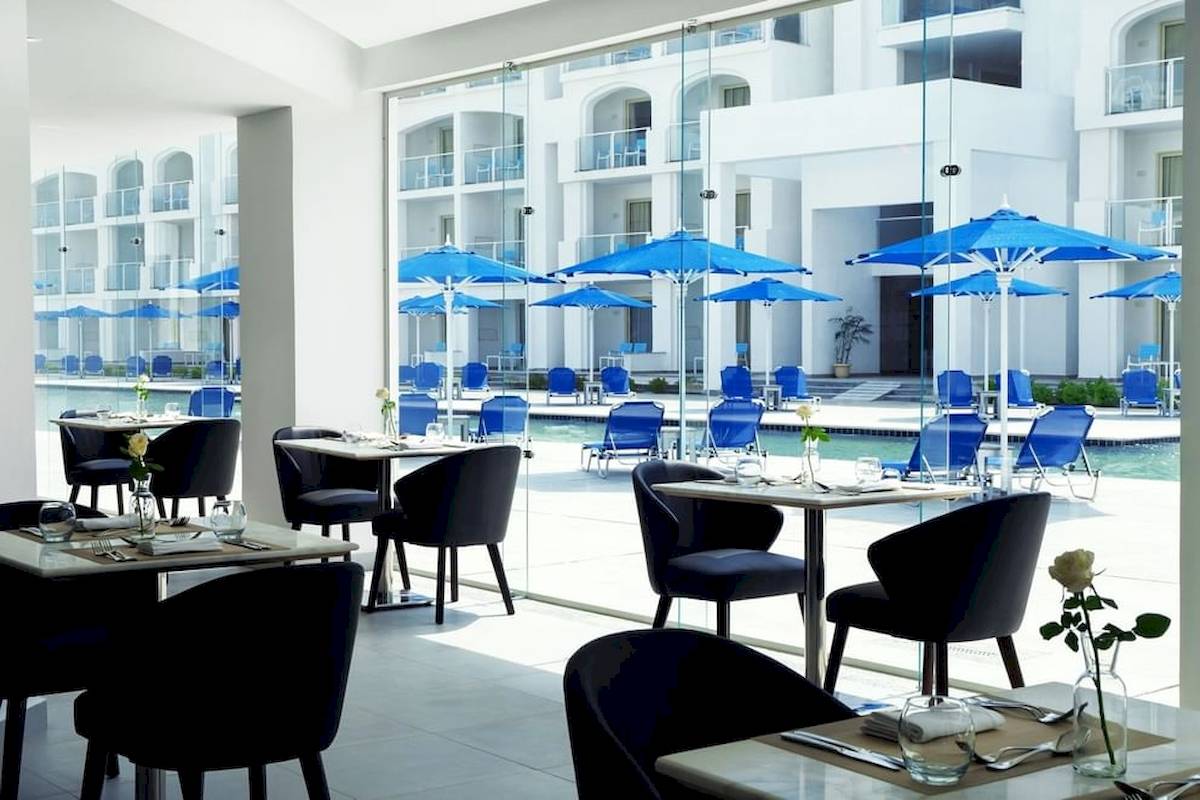 Innenansicht des Restaurants im Pickalbatros Blu Spa Resort mit Tischen und Stühlen.