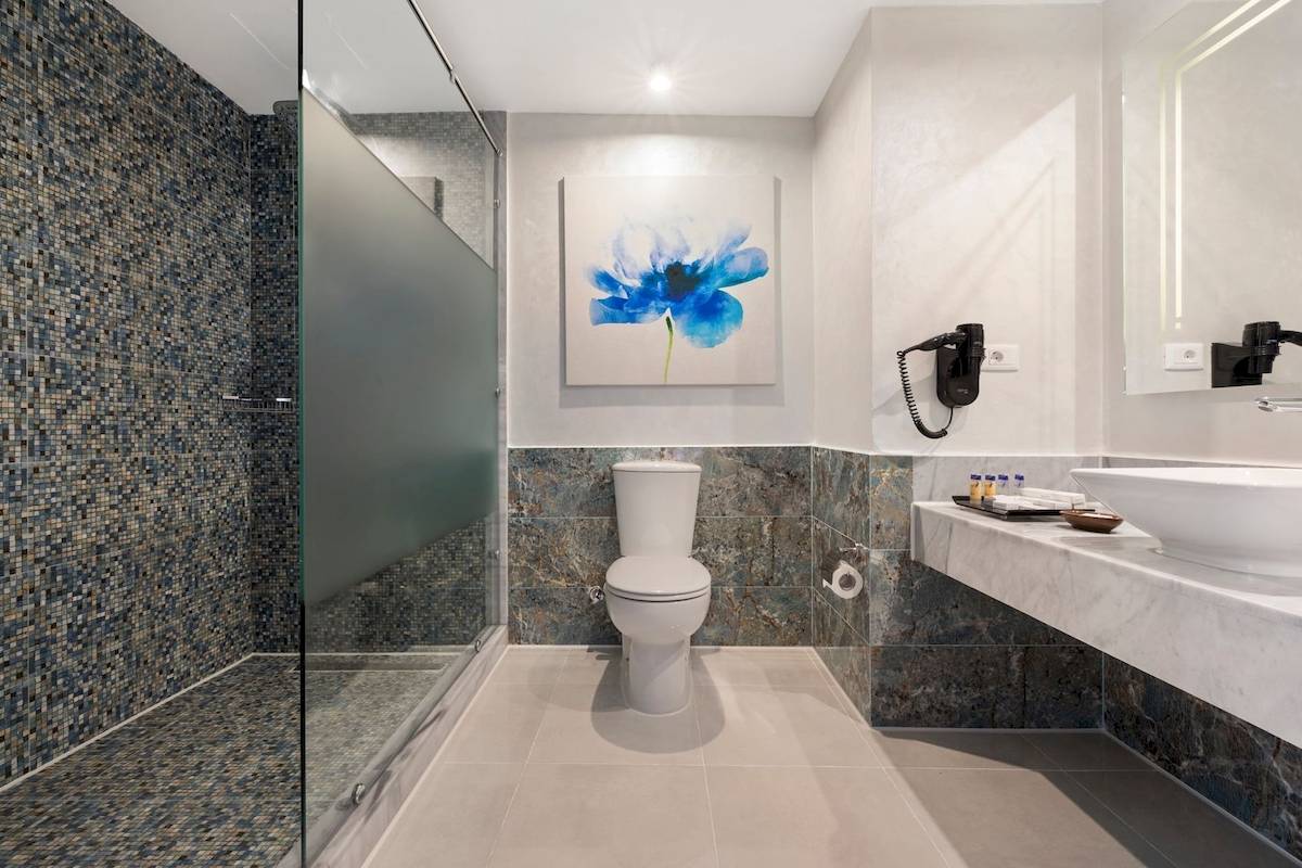 Badezimmer im Pickalbatros Blu Spa Resort mit Glasdusche, Toilette und Waschbecken.