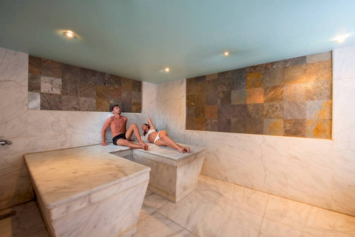 Ein Mann und eine Frau entspannen in der Sauna des Amwaj Beach Clubs.