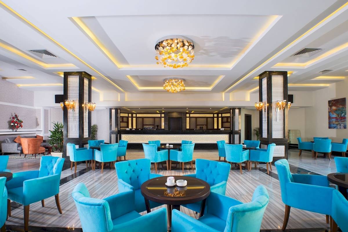 Lobby des Pickalbatros Aqua Vista Resorts mit blauen Stühlen und runden Tischen.