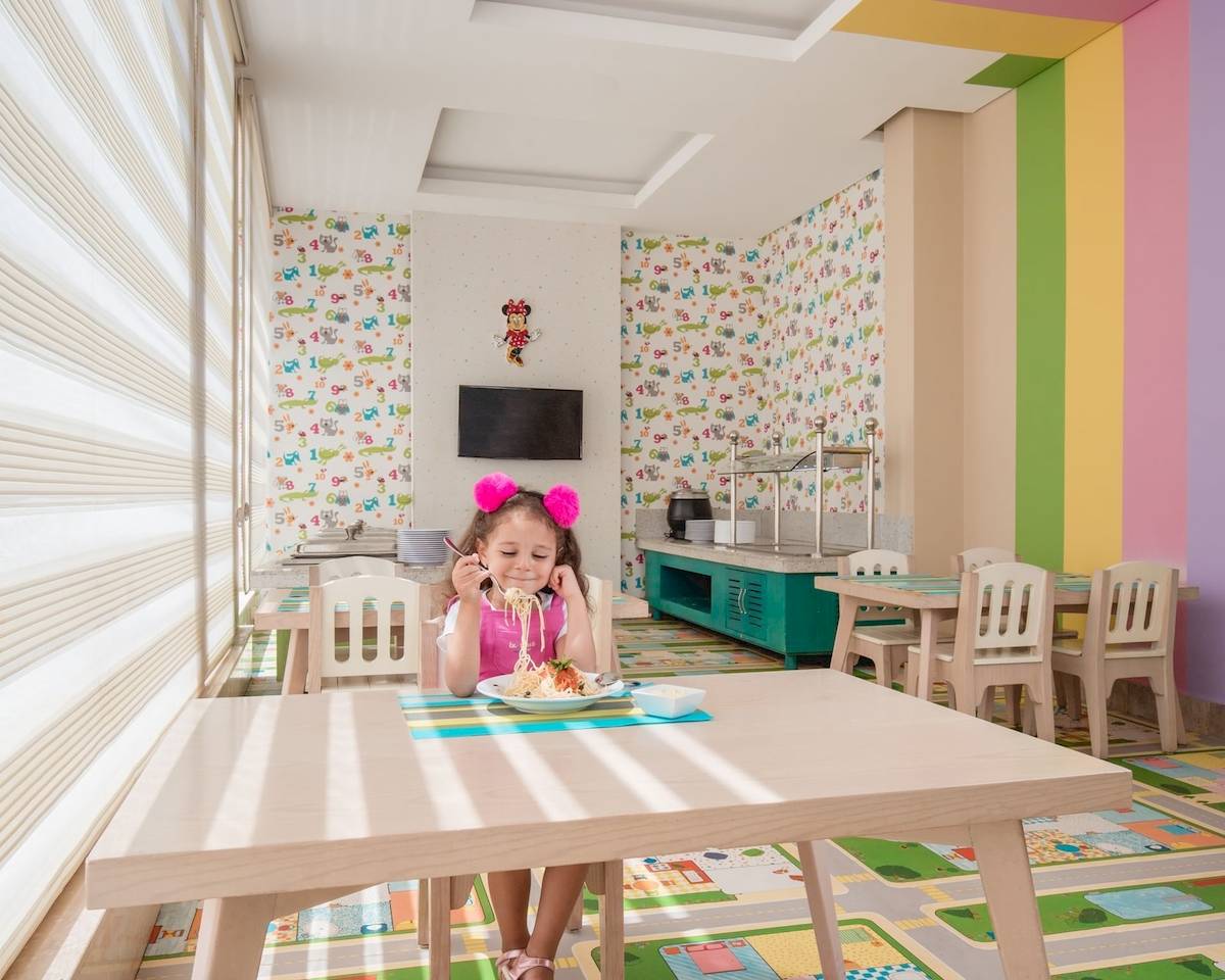 Kleines Mädchen isst Nudeln im Pickalbatros Aqua Vista Resort Kinderzimmer.