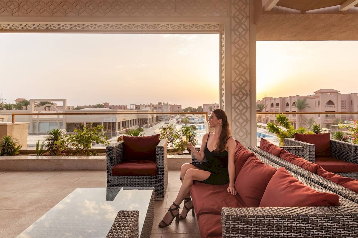 Frau auf dem Balkon des Pickalbatros Aqua Vista Resort, genießt den Blick auf die Stadt.