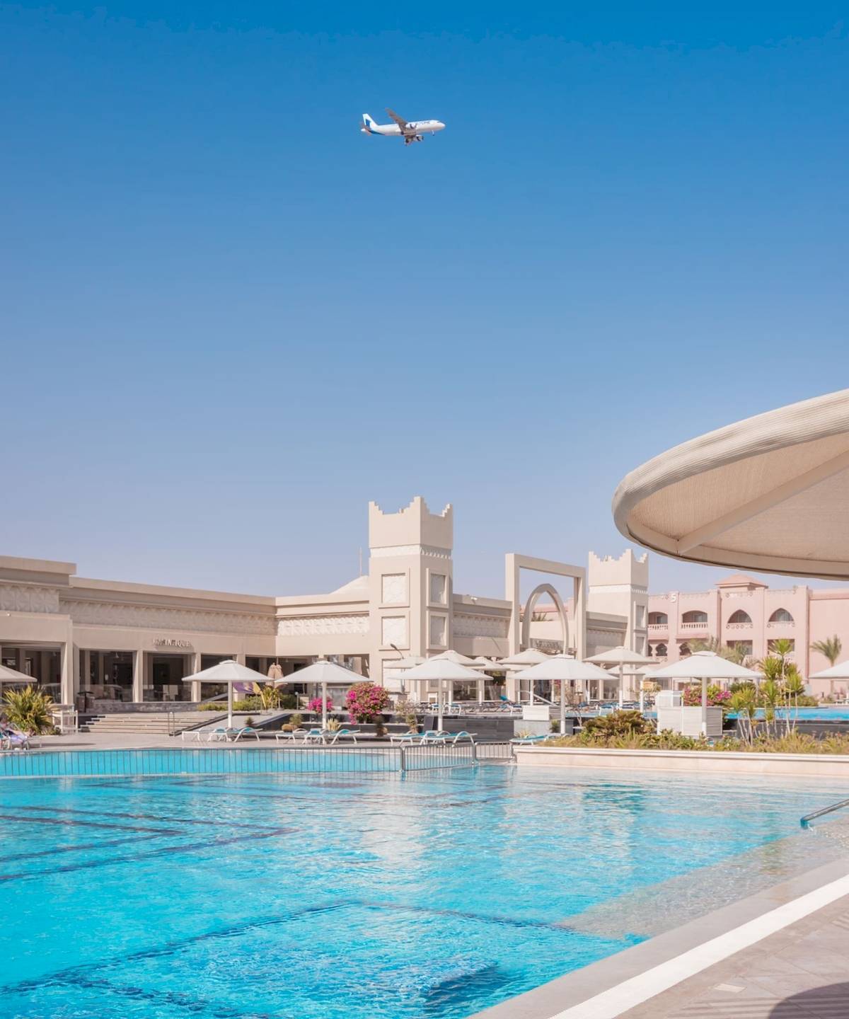 Das Pickalbatros Aqua Vista Resort zeigt einen Pool mit einem fliegenden Flugzeug.