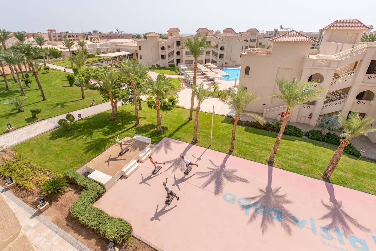 Luftaufnahme des Pickalbatros Aqua Vista Resorts mit mehreren Gebäuden, Swimmingpool und Menschen, die Fitnessgeräte benutzen.
