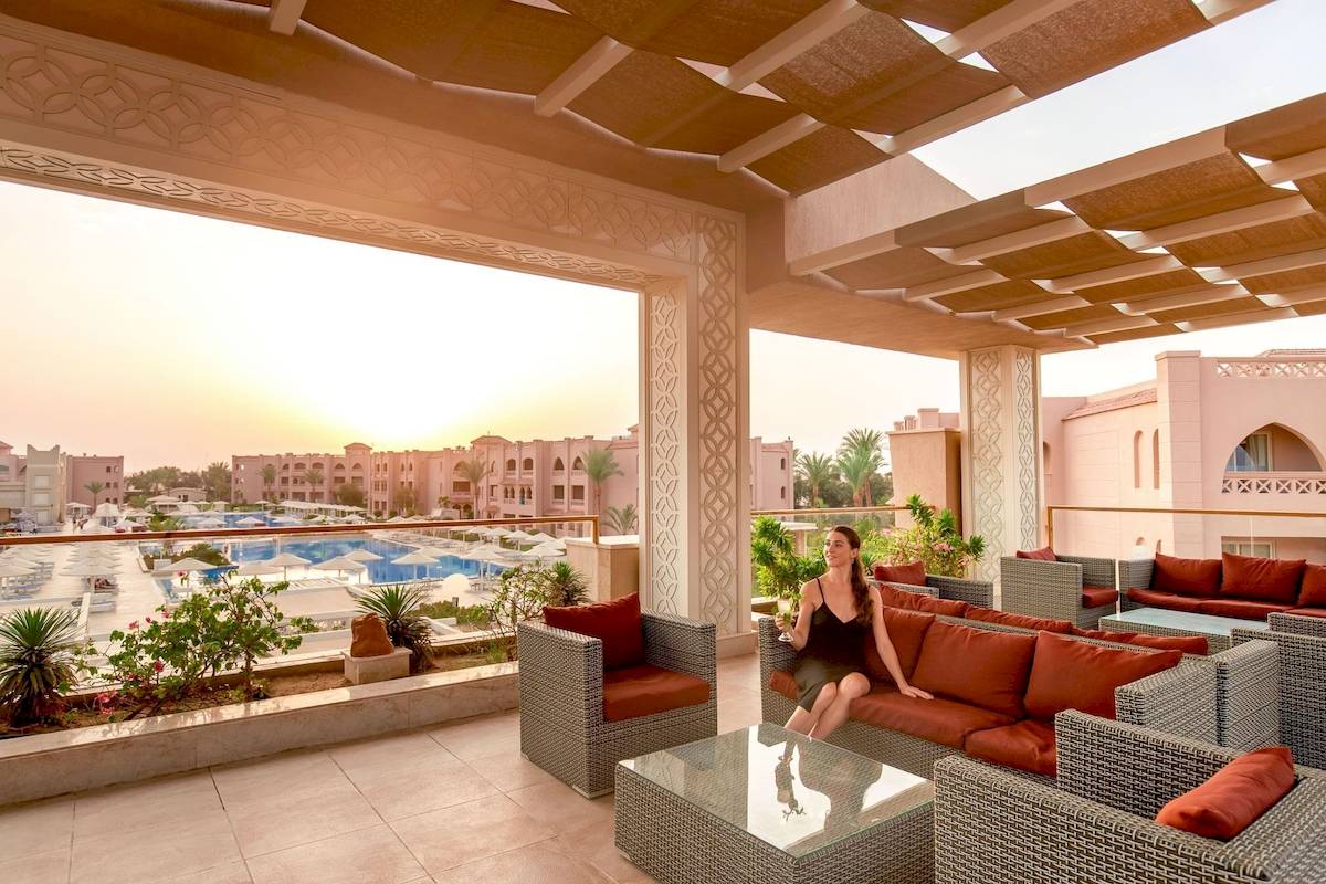 Frau auf der Terrasse des Pickalbatros Aqua Vista Resorts mit Blick auf den Swimmingpool