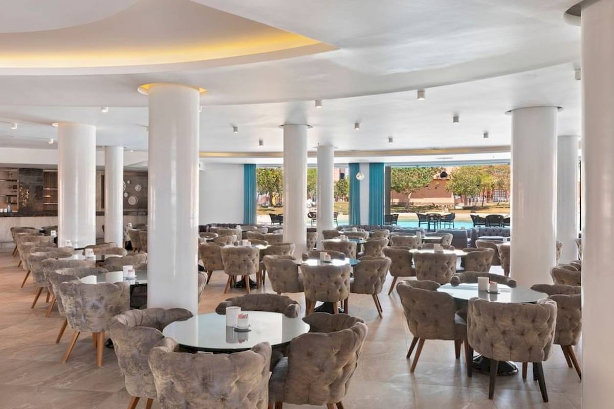 Innenansicht des Restaurants des Pickalbatros Water Valley Resort by Neverland mit vielen Tischen und Stühlen.