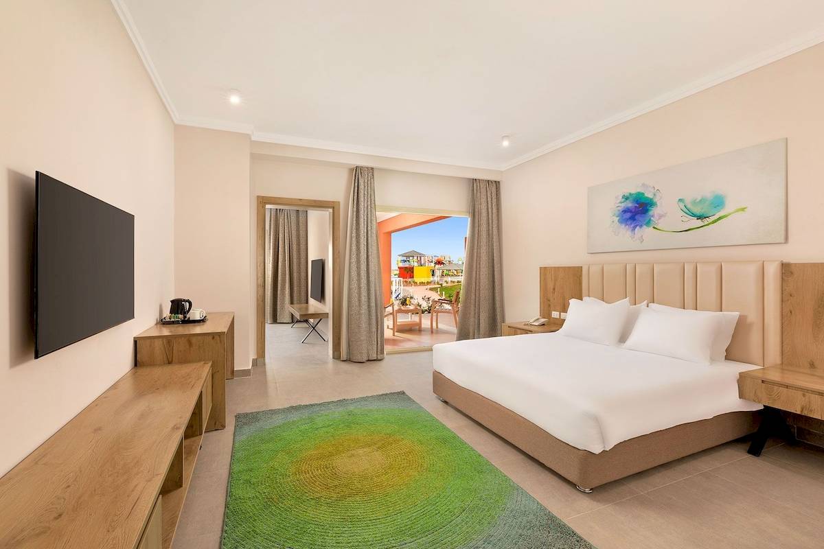 Hotelzimmer im Pickalbatros Water Valley Resort by Neverland mit Flachbildfernseher und grünem Teppich.