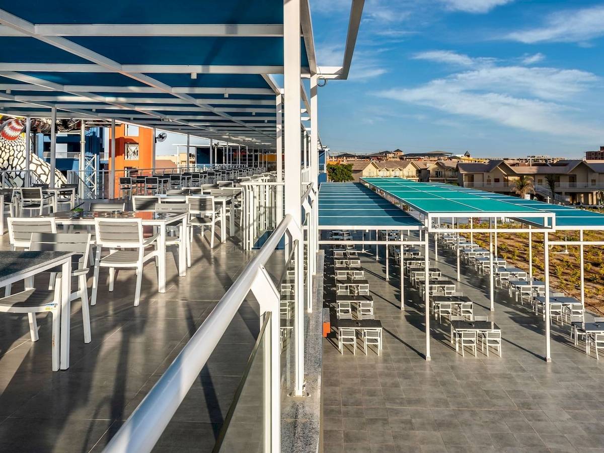 Terrasse des Pickalbatros Water Valley Resorts mit vielen Tischen und Stühlen.