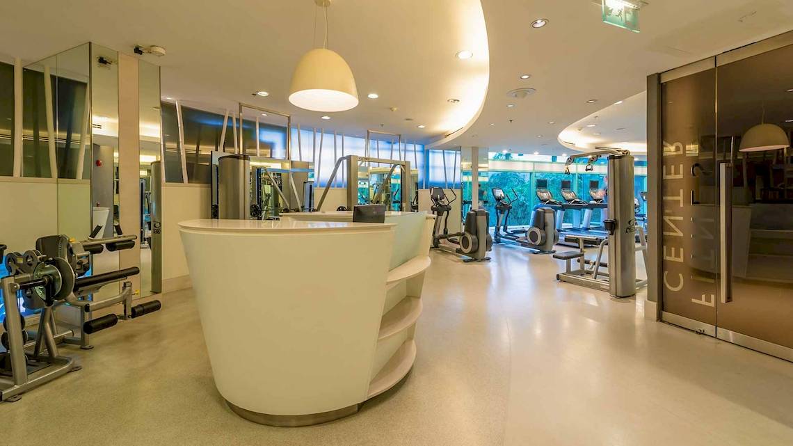 Fitnesscenter im Chatrium Hotel Riverside Bangkok mit modernen Geräten und hellem Ambiente.