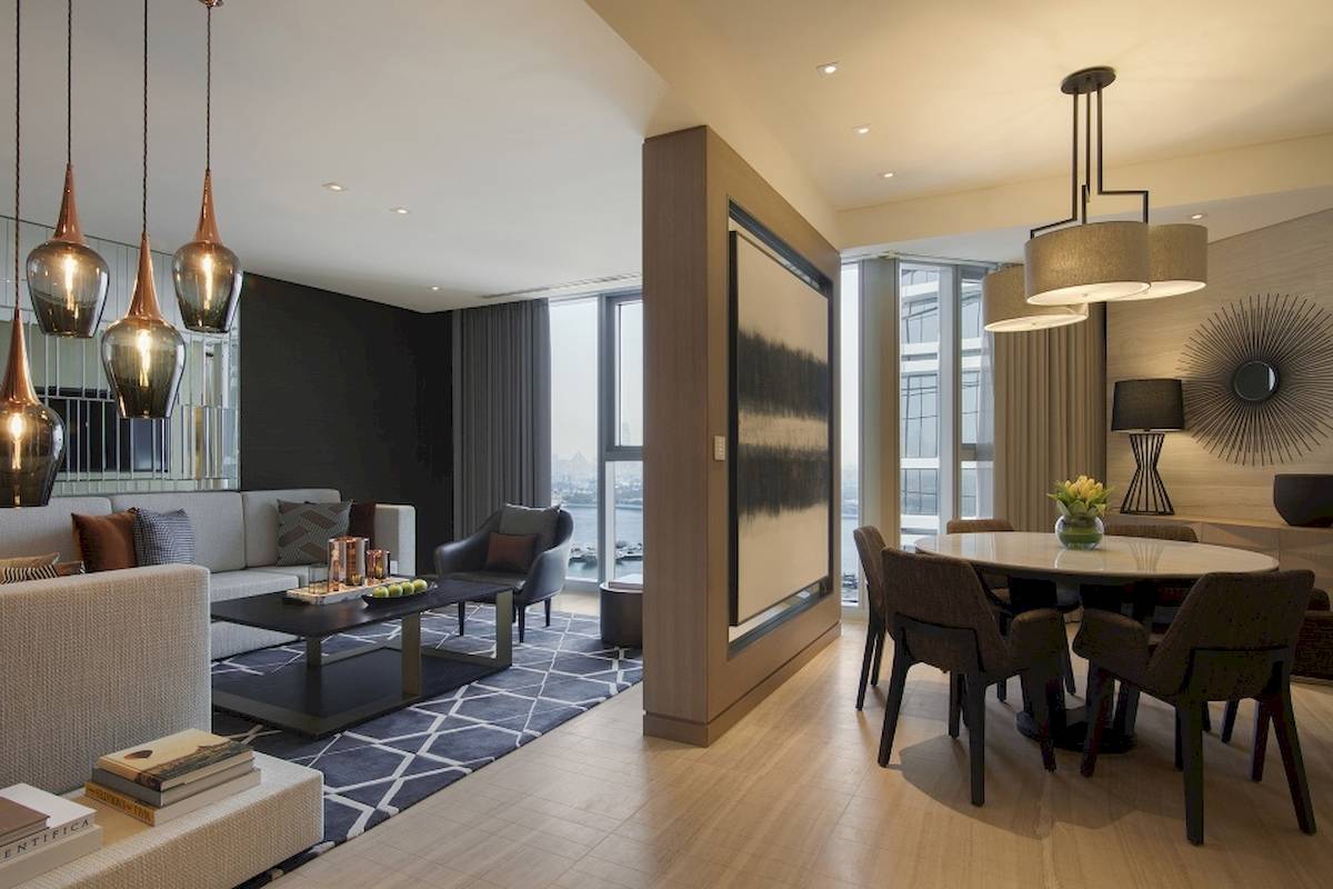 Wohnbereich des Al Bandar Rotana Hotels mit Couch, Tisch und Esstisch