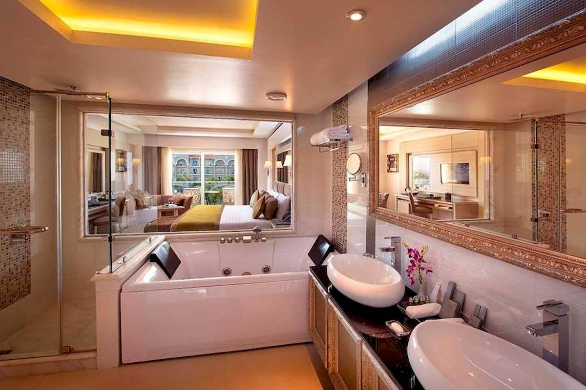 Badezimmer im Premier Le Reve Hotel & Spa mit Badewanne, Dusche, Spiegel und Waschbecken.