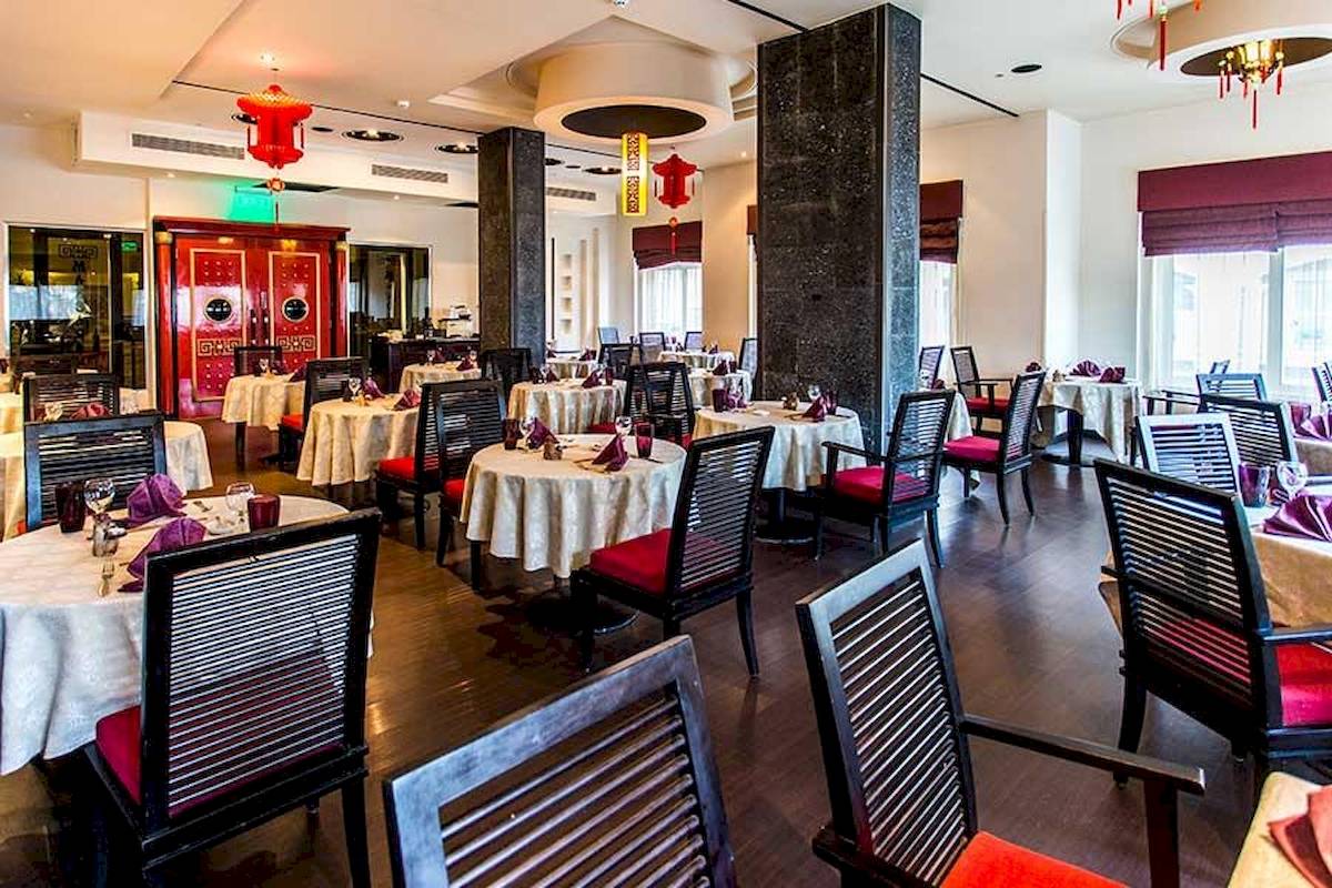 Innenbereich des Restaurants im Premier Le Reve Hotel & Spa mit geräumigen Tischen und Stühlen.