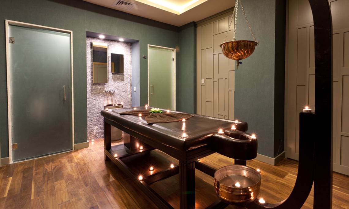 Massagesalon im Sherwood Dreams Resort mit Holzboden und grünen Wänden.