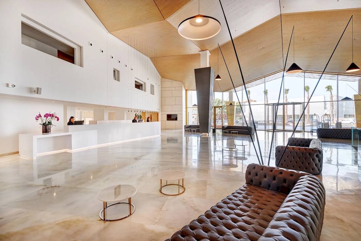 Lobby des Hipotels Gran Playa de Palma mit Marmorboden und modernen Möbeln.