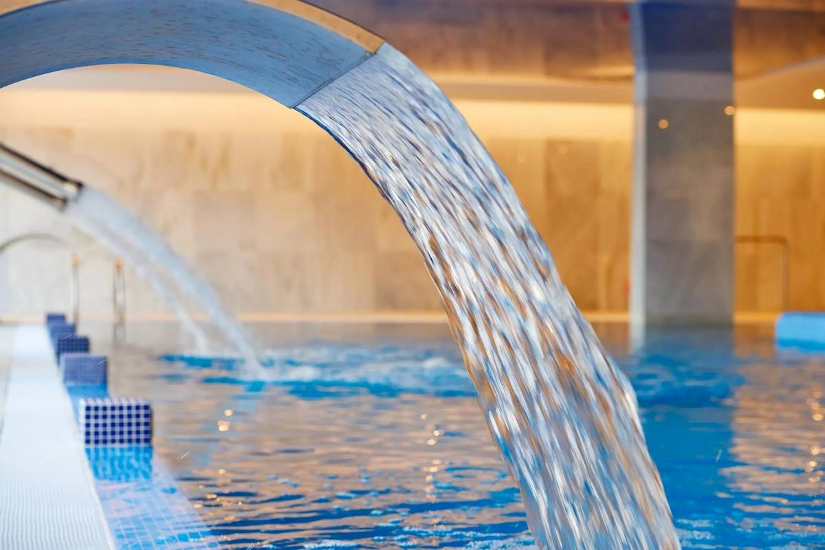 Ein blaues Schwimmbecken im Hipotels Gran Playa de Palma Hotel mit Wasserstrahlen