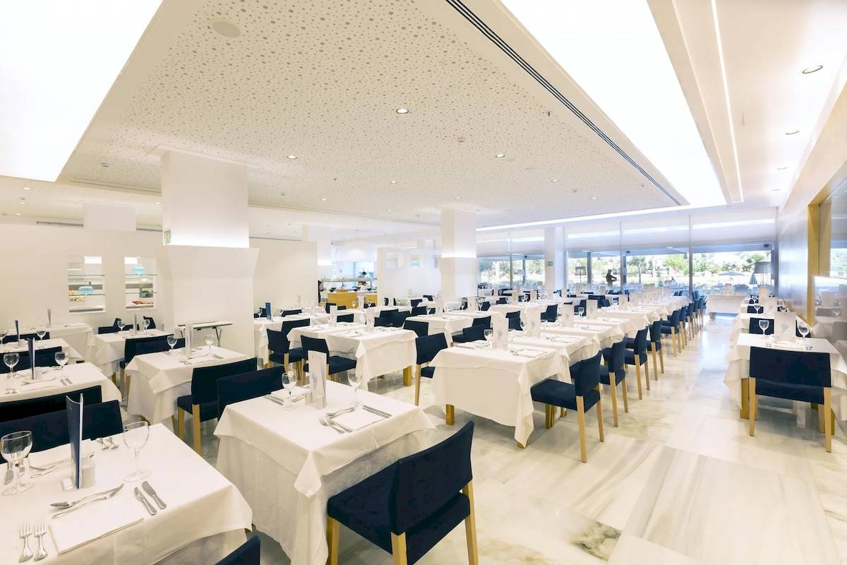 Innenansicht des Restaurants im Hipotels Gran Playa de Palma mit vielen gedeckten Tischen und Stühlen.